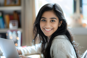 坐在笔记本电脑前面带微笑美女图片